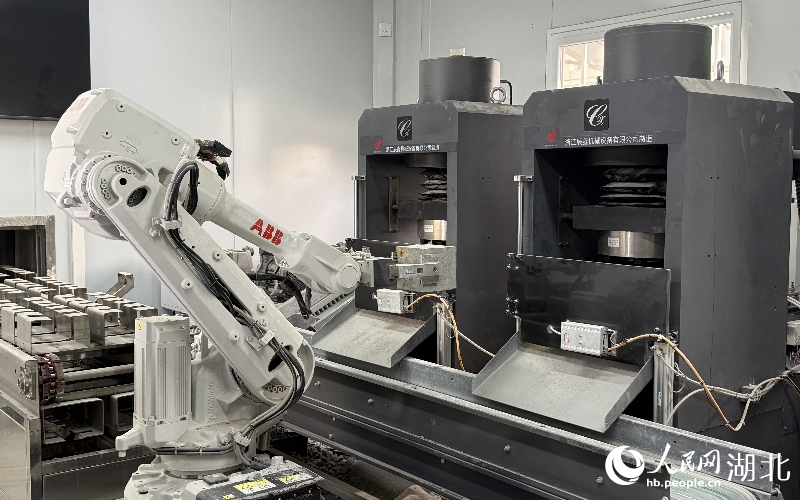 鄂州花湖機(jī)場(chǎng)高速公路二期工程試驗(yàn)室的機(jī)械臂將試件放入壓力機(jī)檢測(cè)。人民網(wǎng)記者 周恬攝